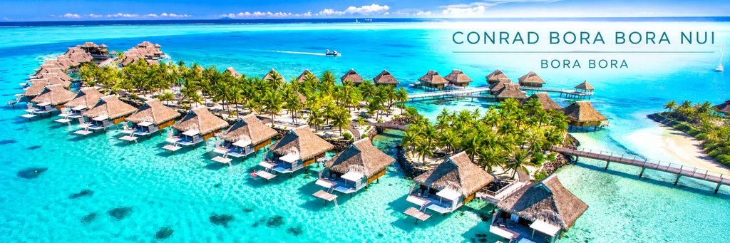 Aerial view of Conrad Bora Bora Nui featuring luxury overwater villas, wooden walkways, palm-covered islands, and crystal-clear turquoise lagoon waters.