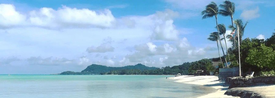 Matira Beach in Bora Bora with clear turquoise water, soft white sand, and palm trees along the shoreline