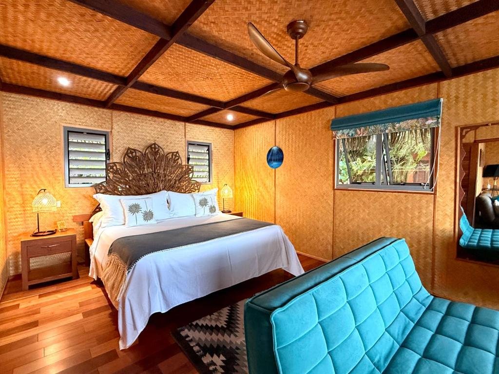 Tropical guestroom interior with woven walls and wood details at Eden Private Island