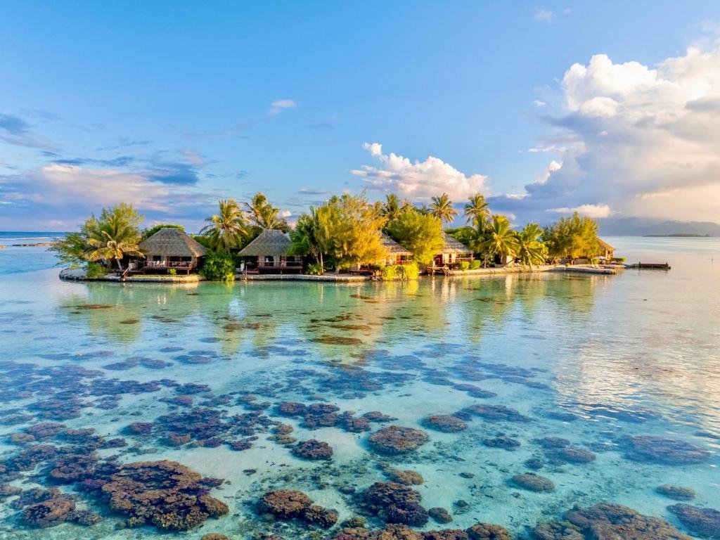 Small private island with bungalows and shallow lagoon at Eden Private Island Tahaa