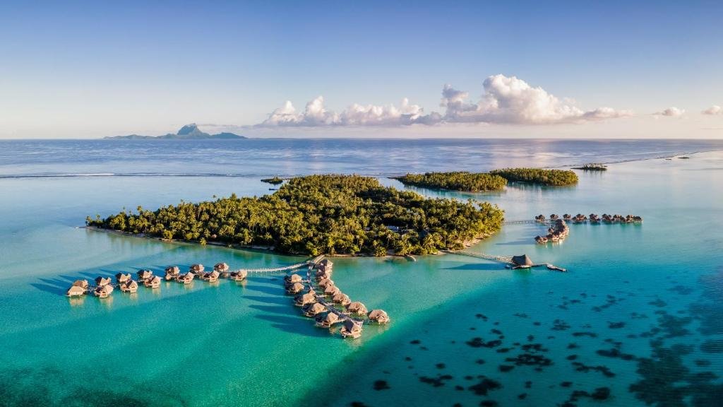 Aerial view of overwater bungalows and lagoon at Le Taha’a by Pearl Resorts