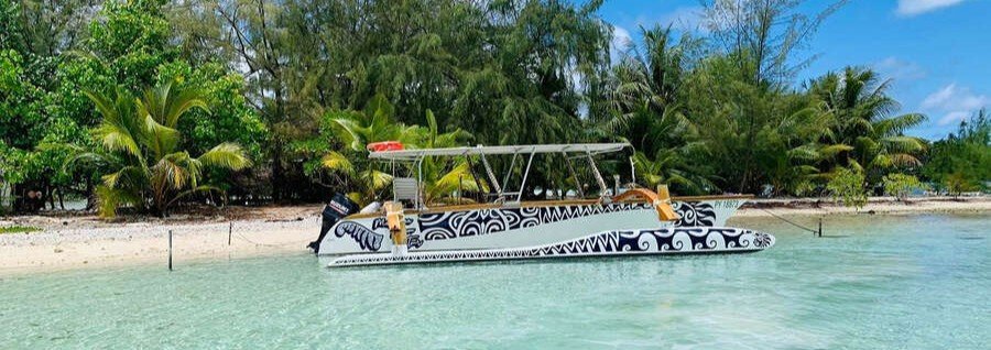 Traditional Polynesian pirogue boat in shallow lagoon near tropical beach in Huahine, French Polynesia
