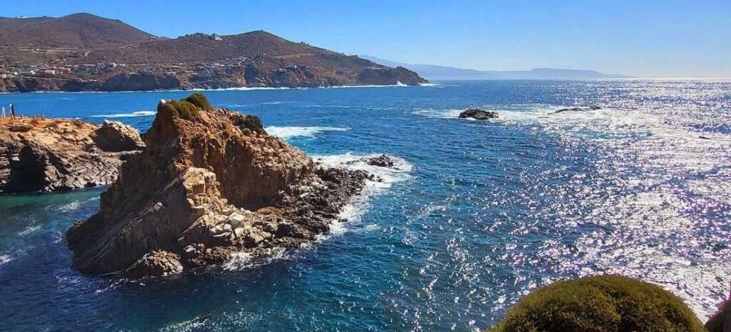 Ensenada beaches with dramatic rocky coastal cliffs overlooking the deep blue Pacific Ocean, featuring rugged shoreline formations, sparkling water, and scenic mountain views in Baja California Mexico