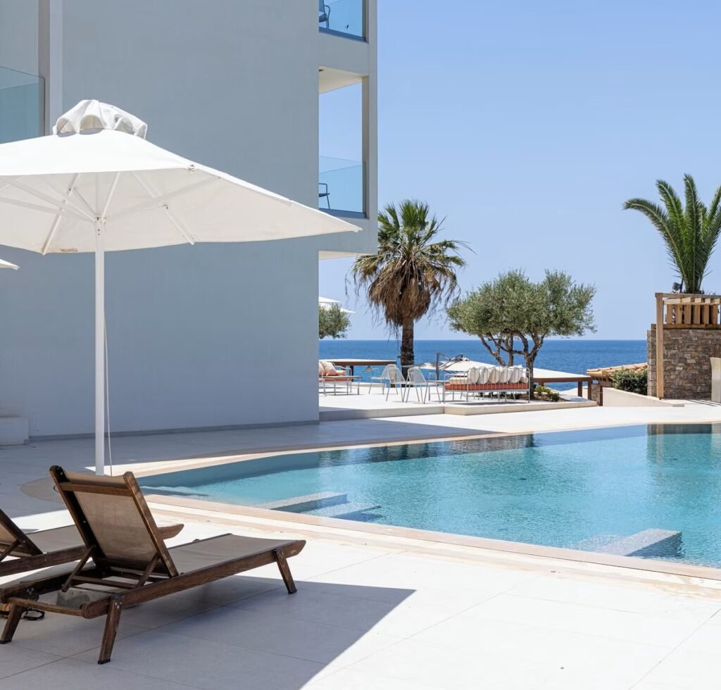 luxury pool area with sun loungers and ocean view at PHEIA Vriniotis Resorts in Katakolon
