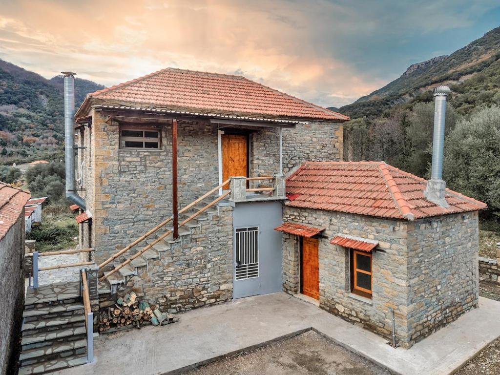 stone villa with red tile roof surrounded by mountains and countryside at Villa Riverwood Greece