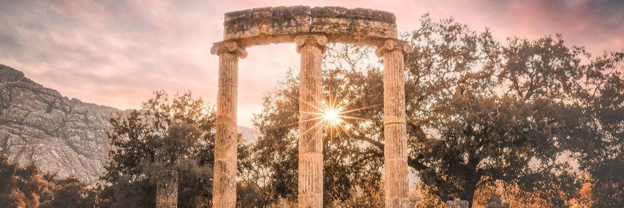 Ancient Olympia ruins with stone columns and sunlight shining through historic Greek temple remains