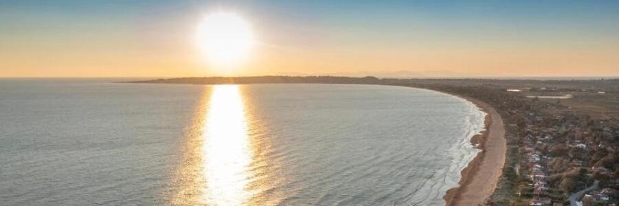 sunset over Katakolon beach with golden light reflecting on the sea and coastline