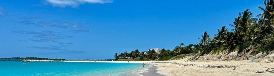 Wide stretch of white sand and turquoise water at Cabbage Beach in Nassau.