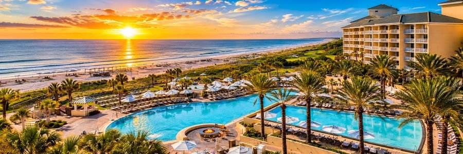 Omni Amelia Island Resort & Spa in Florida featuring beachfront pools, palm trees and Atlantic Ocean views at sunset.