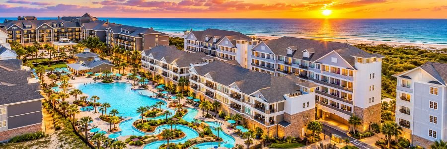 The Henderson Beach Resort in Destin, Florida, featuring lagoon-style pools, coastal resort buildings and Gulf views at sunset.
