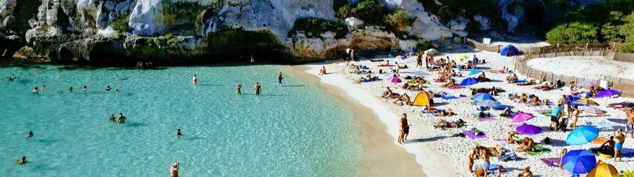 Cala Macarella Menorca Spain turquoise cove with cliffs and beachgoers