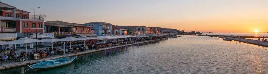 Lefkada Town harbor at sunset with waterfront cafes and calm water