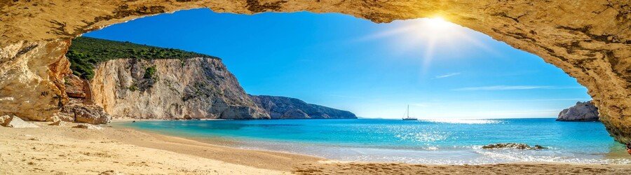 Cave beach on Lefkada’s west coast with turquoise water, cliffs, and golden sand