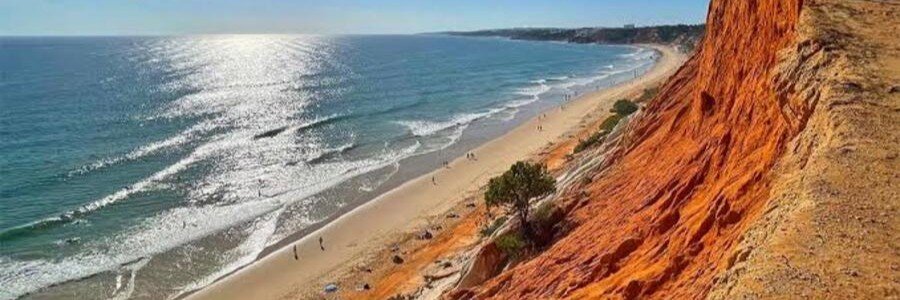 10 Most Beautiful Beaches | Praia da Falésia Praia da Falésia in Portugal’s Algarve with golden sand, Atlantic waves, and towering orange-red cliffs.