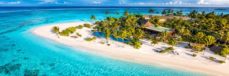 The Brando in French Polynesia with a white sand beach, turquoise lagoon, tropical palms, and luxury resort villas.