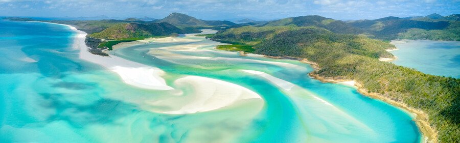 10 Most Beautiful Beaches | Whitehaven Beach Aerial view of Whitehaven Beach in Australia with swirling white sand, turquoise water, and green Whitsunday Islands.