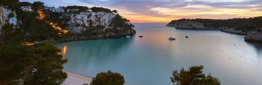 Cala Galdana Menorca Spain cove with calm turquoise water and cliffs at sunset
