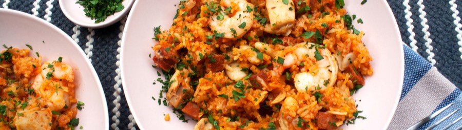 Paella Valenciana close-up with rice, seafood, and herbs on a plate