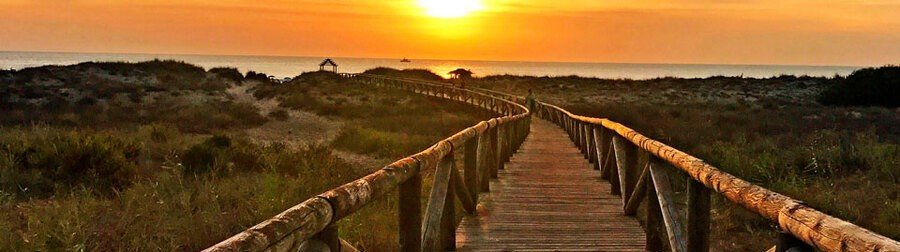 Zahara de los Atunes Spain sunset boardwalk leading to beach over dunes