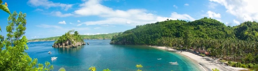 Peaceful bay surrounded by lush green hills and clear blue waters near the Gili Islands.