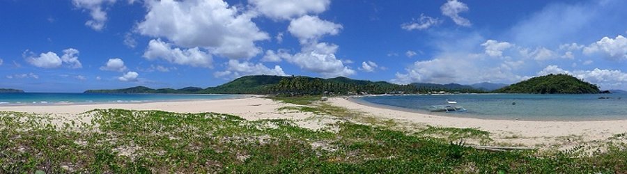 Panoramic view of a white sand beach with clear blue skies, lush hills, and calm turquoise waters on Luzon Island.
