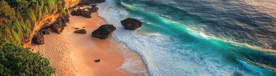 Cliff-lined beach in the Maluku Islands, Indonesia, with turquoise waves, golden sand, and rugged coastal scenery