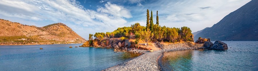 Aerial view of Limeni’s clear turquoise bay surrounded by stone houses and hills in the Mani Peninsula.