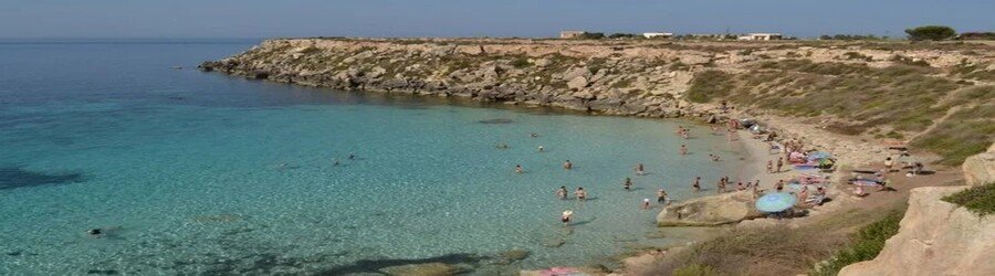 Cala Azzurra beach in Favignana with clear turquoise water and rocky shoreline