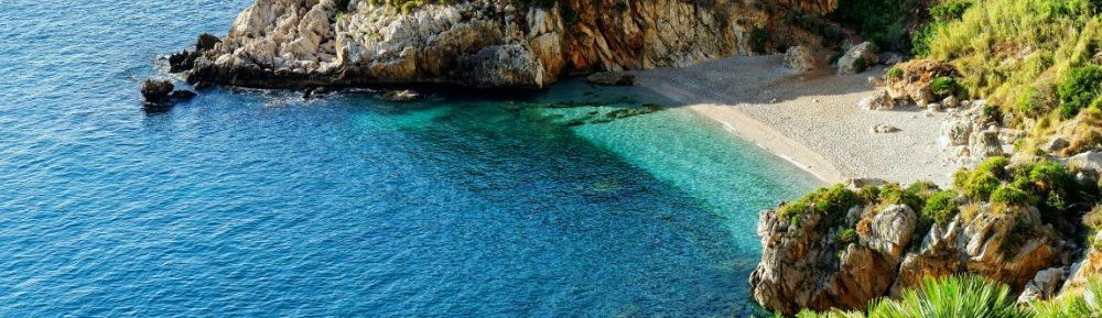 Rocky beach cove in the Egadi Islands with clear blue water and stone shoreline