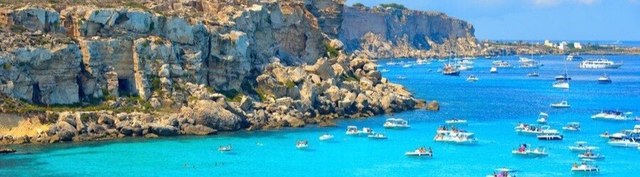 Favignana island coastline with turquoise water and boats in the Egadi Islands