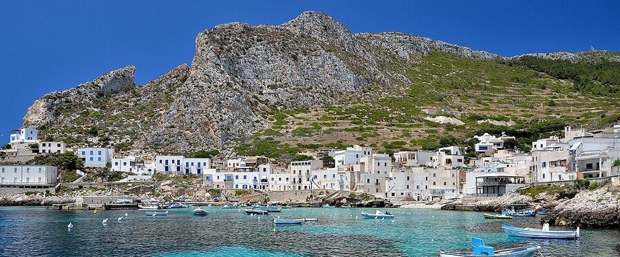 Levanzo village harbor with white buildings and fishing boats in the Egadi Islands