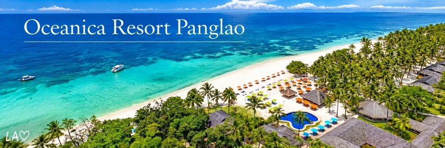 Aerial view of Oceanica Resort Panglao in Bohol, featuring a white-sand beach, turquoise ocean waters, colorful beach umbrellas, tropical palms, and a resort swimming pool.