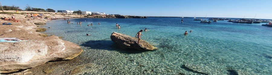 Spiaggia di Marasolo beach in Favignana with clear shallow water and rocky shore