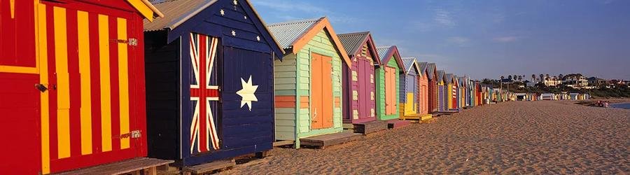 Brighton Bathing Boxes in Melbourne, Victoria painted in colorful designs along the beach.