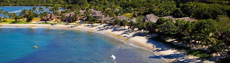 Palm-lined beach at Pacific Harbour with gentle waves and tropical greenery along the shoreline.