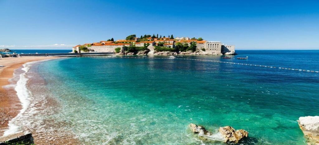 Visit Beautiful Montenegro with a view of Sveti Stefan island, golden beach, and clear Adriatic waters.