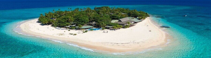 Aerial view of Wailoaloa Beach with a long stretch of sand and gentle waves near Nadi Bay.