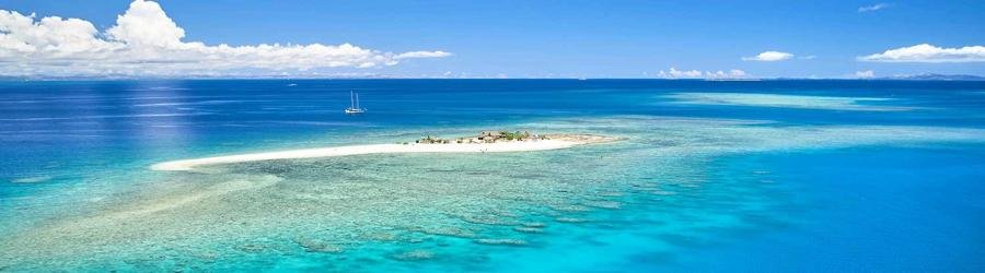 Remote sandbar island surrounded by turquoise blue waters and coral reefs near Viti Levu, Fiji.