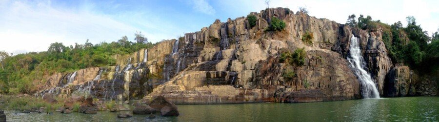 Wide view of cascading waterfalls surrounded by lush forest in Vietnam’s Central Highlands.