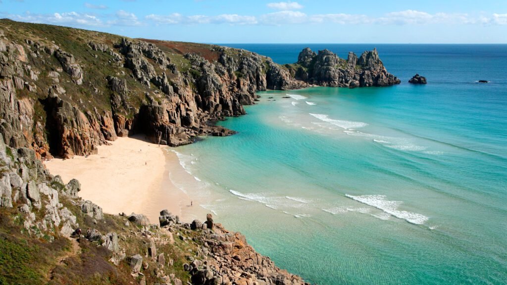 turquoise waters and rugged cliffs along a secluded Cornwall UK beach