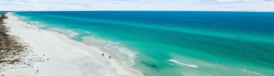 aerial view of grayton beach florida with emerald green water and wide sandy coastline