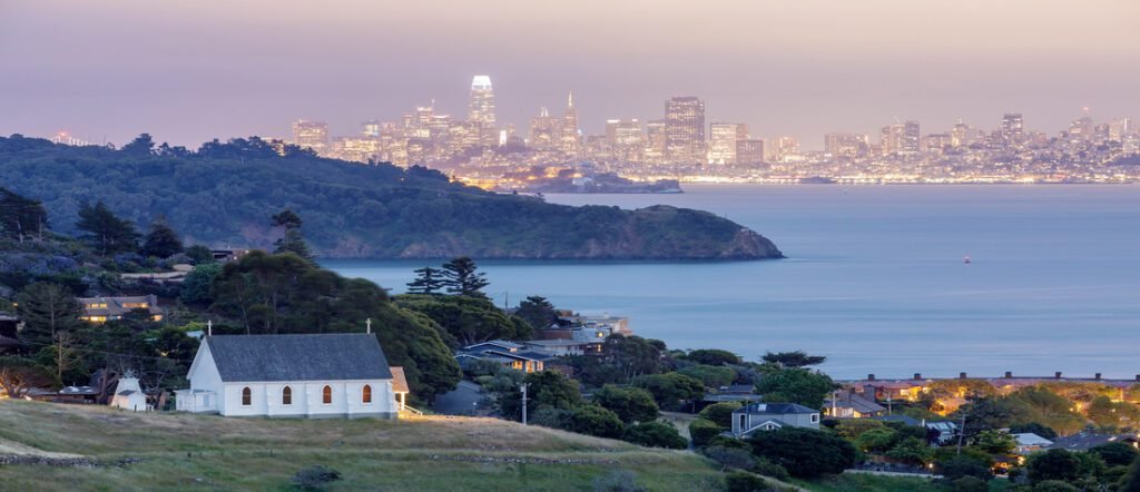 Scenic view of Marin County with coastal homes and hills overlooking the San Francisco Bay at dusk.  Marin County Beaches.
