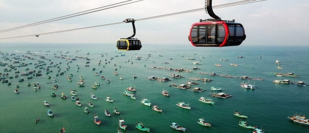 Colorful cable cars glide above fishing boats and turquoise waters in Phu Quoc  Vietnam.