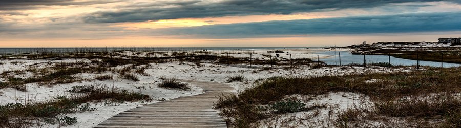 grayton beach florida sand dunes with wooden path under dramatic cloudy sky