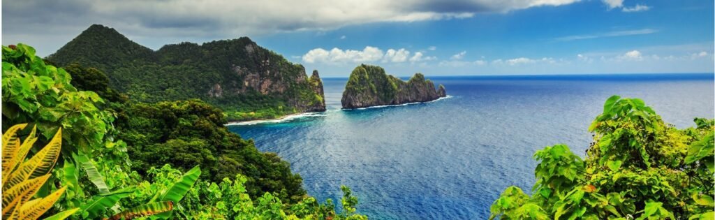 Overlook of cliffs and sea framed by jungle foliage.