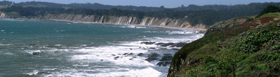 Cliffs and rocky shoreline along the Northern California coast with waves breaking below.