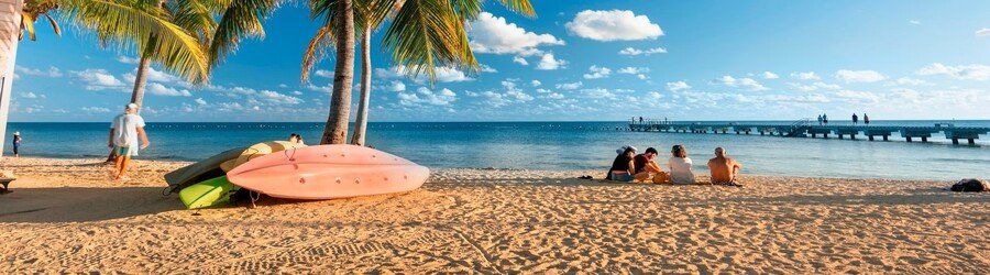 People relaxing on Smathers Beach with palm trees and soft sand near Key West.