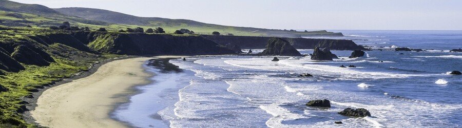 Wide sandy beach and rugged offshore sea stacks along the Sonoma County coast.