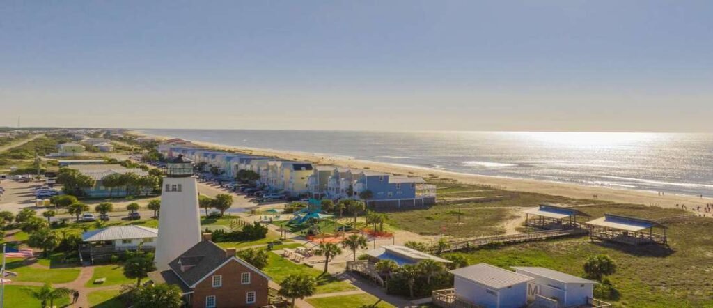 Aerial view of St. George Island Florida lighthouse, beaches, and coastal homes under clear blue skies.
