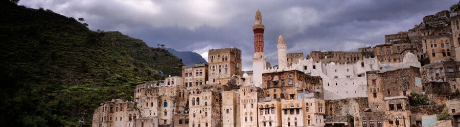 Ancient Yemeni mountain village with traditional stone buildings built into the hillside.